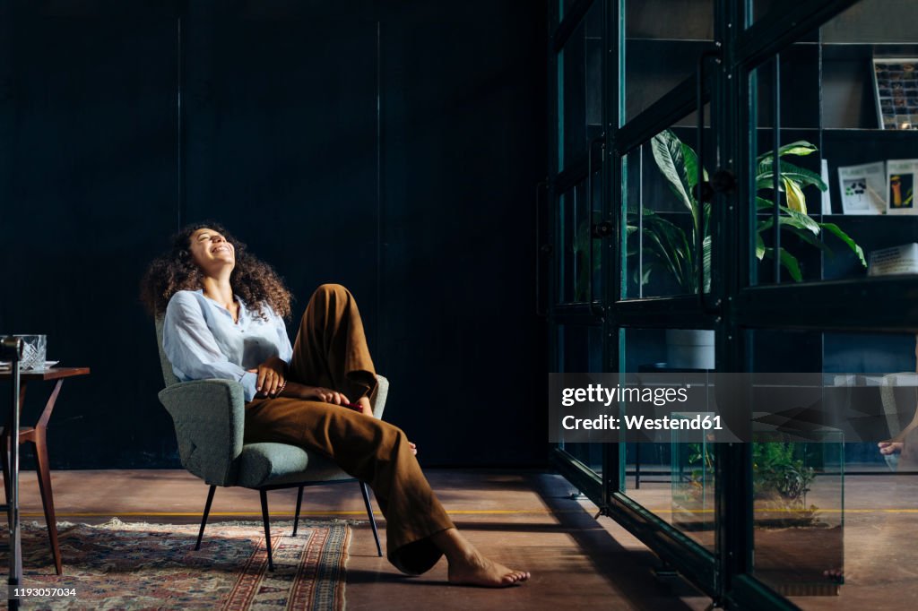 Young businesswoman relaxing in loft office