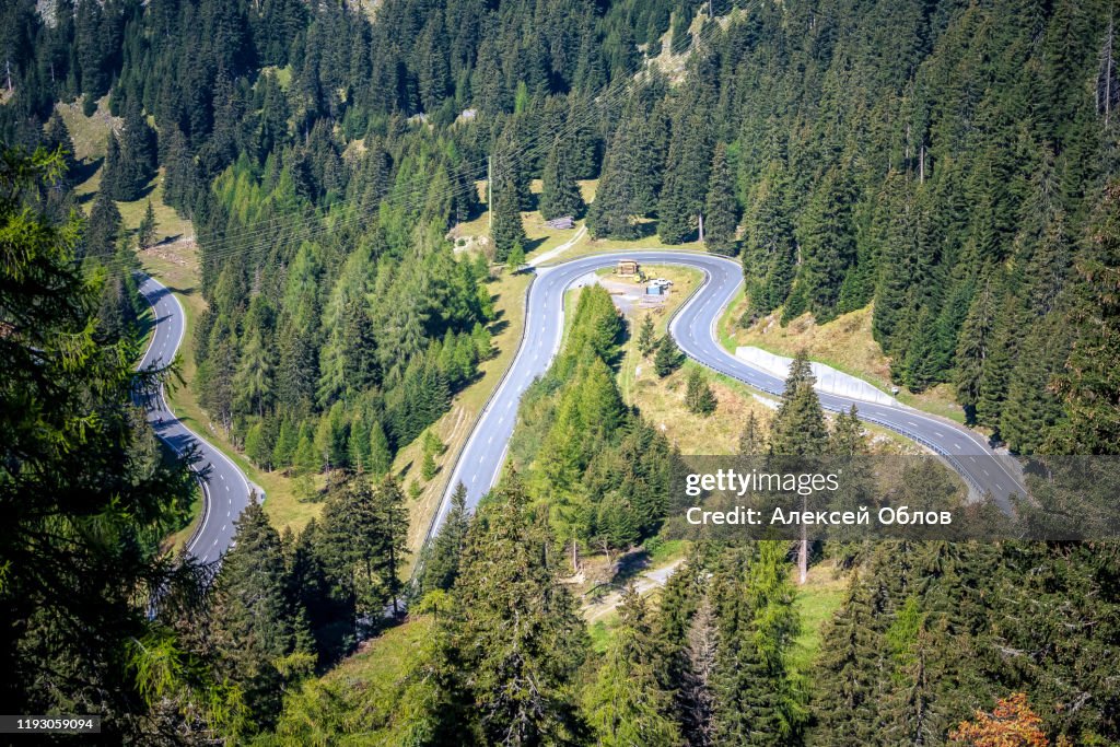 Aerial view of road passing through the green forrest and mountain