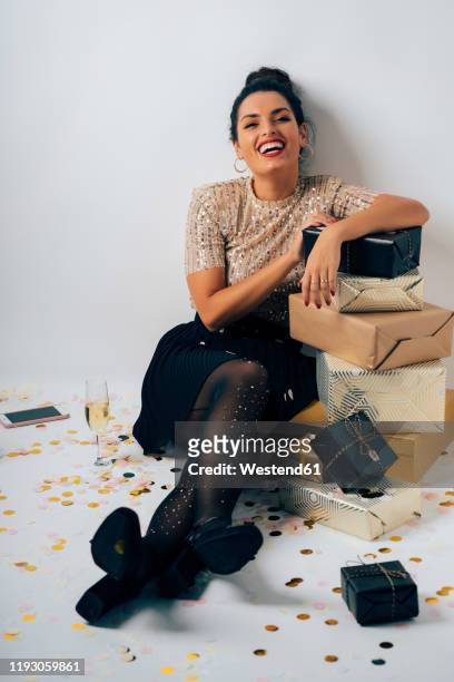 portrait of young woman dressed for a party, celebrating christmas with gifts and champagne - gift lounge stock-fotos und bilder
