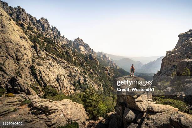 female hiker standing on viewpoint, aiguilles de bavella, corsica, france - corse fotografías e imágenes de stock