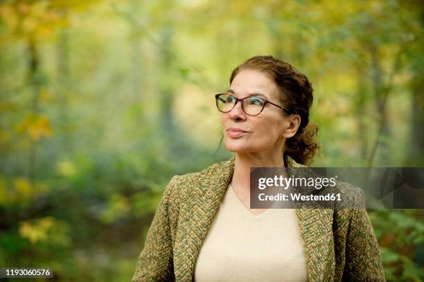 portrait of a mature woman in a autumn forest - looking around stock pictures, royalty-free photos & images
