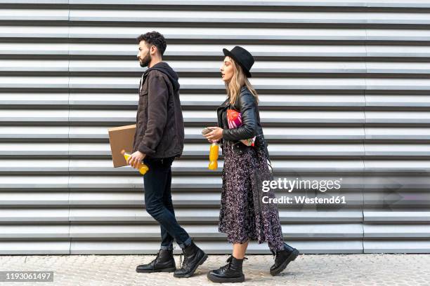 young couple with purchases in the city - side view carrying stock pictures, royalty-free photos & images