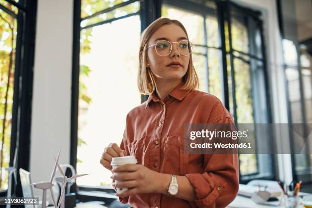 businesswoman having a coffee break in office - coffee plant stock-fotos und bilder