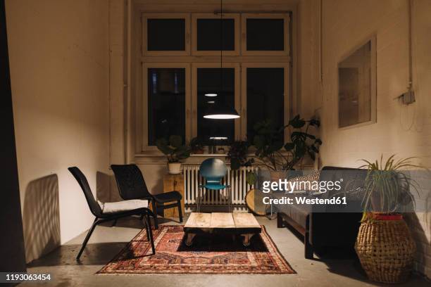 lounge room in an office at night - imbrunire foto e immagini stock