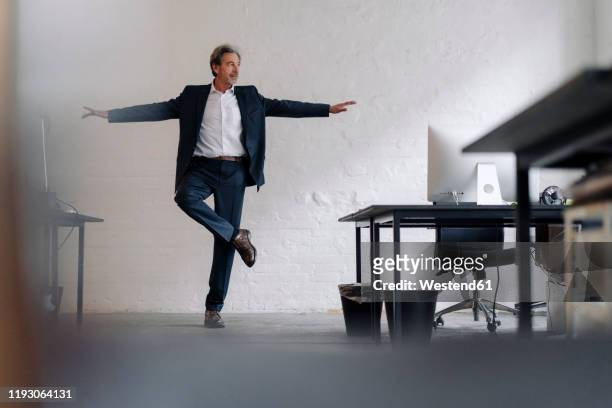 senior businessman doing a yoga exercise in office - office yoga stock pictures, royalty-free photos & images