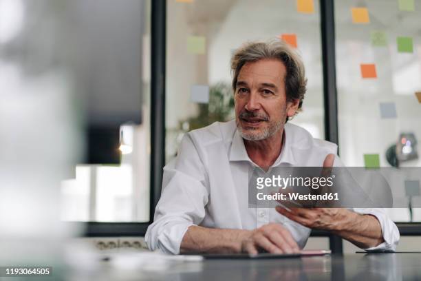 senior businessman in conference room in office - gesturing male stock pictures, royalty-free photos & images