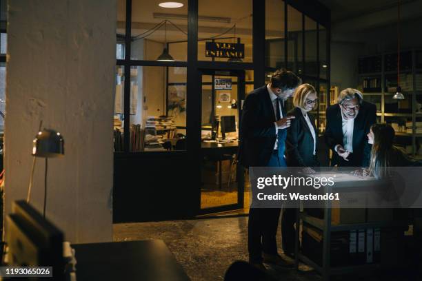 business people and girl looking at shining tablet in office - executive board extraordinary assembly stock pictures, royalty-free photos & images