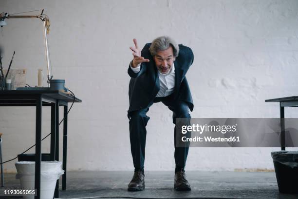 senior businessman doing gymnastics in office - bending over stock pictures, royalty-free photos & images