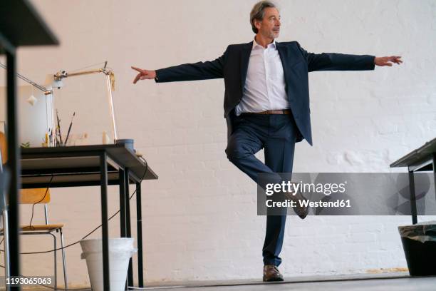 senior businessman doing a yoga exercise in office - standing on one leg fotografías e imágenes de stock