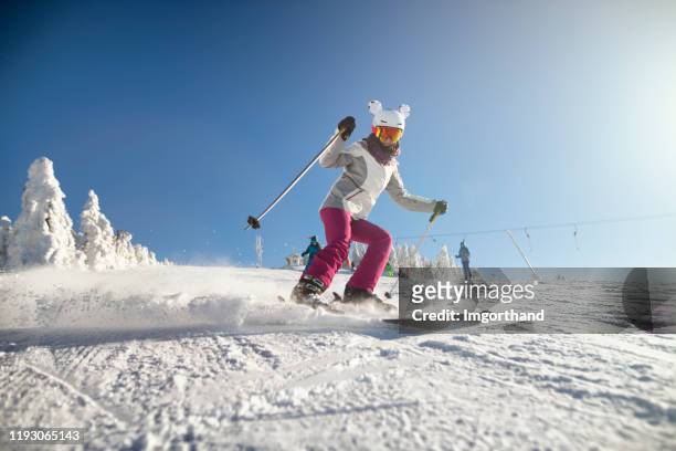 tiener meisje met familie skiën op een mooie winterdag - alpineskiën stockfoto's en -beelden