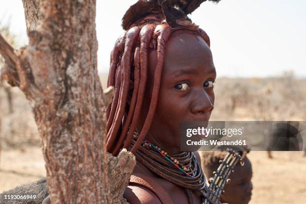 portrait of a himba woman sticking out tongue, opuwo, namibia - himba stock-fotos und bilder