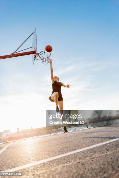 blonde woman playing basketball in cologne, germany - wurf oder sprungdisziplin damen stock-fotos und bilder