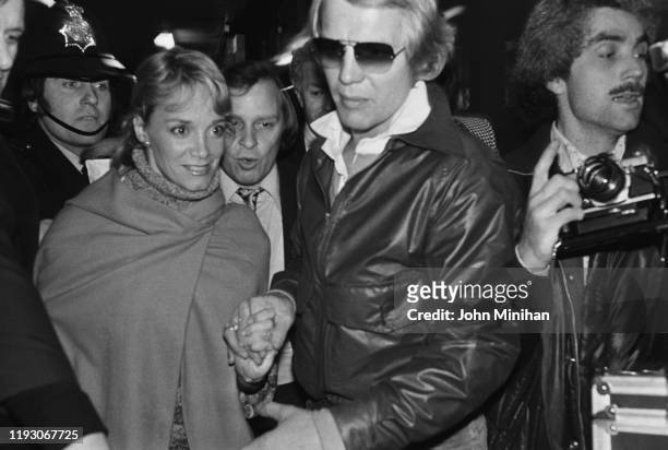 American actors David Soul and Lynne Marta surrounded by photographers and police as they arrive at Heathrow Airport, London, UK, 11th March 1977.