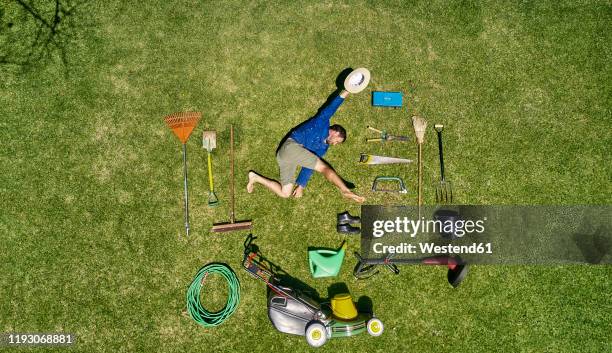 view from above of a gardener in laying on the grass with all the tools he need for take care of garden - lawnmowing stock pictures, royalty-free photos & images