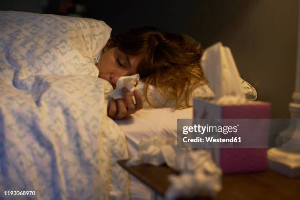 sick woman using tissues in the bed - facial tissue stock pictures, royalty-free photos & images