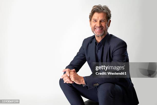 portrait of laughing mature businessman against light background - man in suit white background stock pictures, royalty-free photos & images