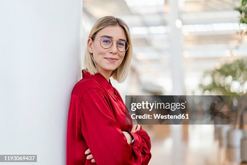 Portrait of a confident young businesswoman leaning against a column Portrait of a confident young businesswoman leaning against a column