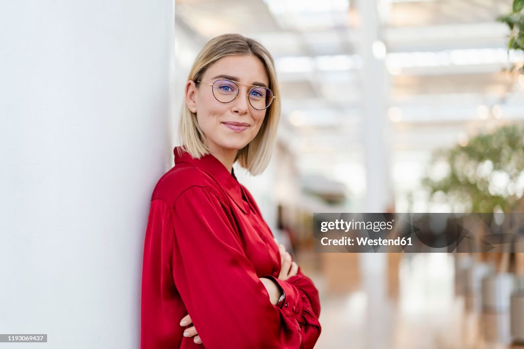 Portrait of a confident young businesswoman leaning against a column