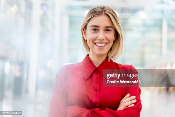 portrait of a confident young businesswoman wearing red shirt - auslachen blick in die kamera stock-fotos und bilder