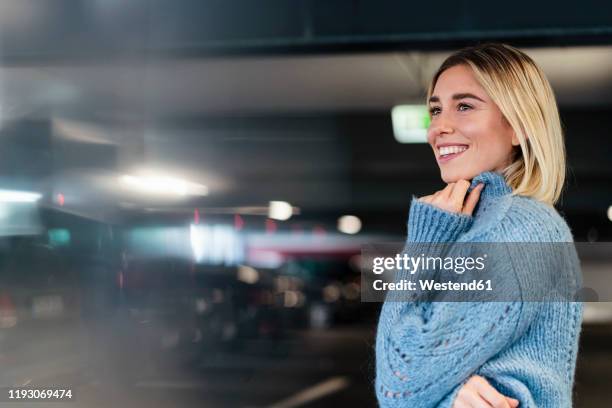 portrait of a smiling young woman in a parking garage - looking around stock pictures, royalty-free photos & images