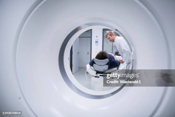 patient in hospital during ct examination and radiologist - tecnología medica fotografías e imágenes de stock