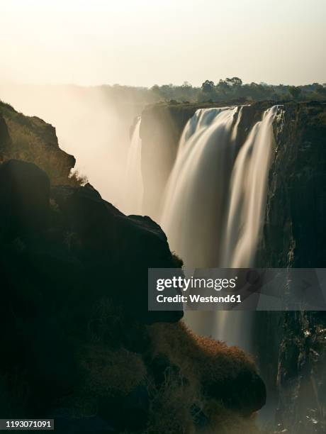 victoria falls at sunset, zimbabwe - victoria falls sunset stock pictures, royalty-free photos & images