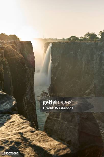 victoria falls at sunset, zimbabwe - victoria falls sunset stock pictures, royalty-free photos & images