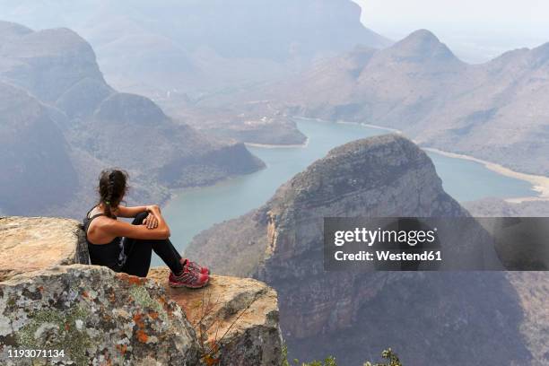 woman sitting on a rock with beautiful landscape as background, blyde river canyon, south africa - blyde river canyon stock pictures, royalty-free photos & images