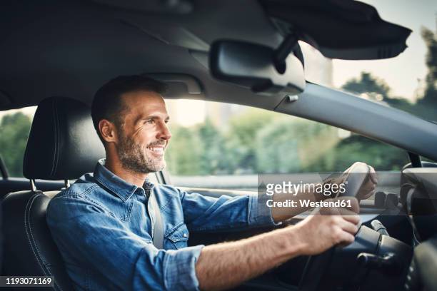 handsome man driving a car - driving stock pictures, royalty-free photos & images