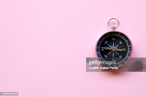 close-up of compass against pink background - east stock pictures, royalty-free photos & images