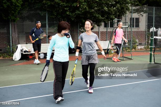 a woman who enjoys tennis with good teammates - japanese tennis stock pictures, royalty-free photos & images