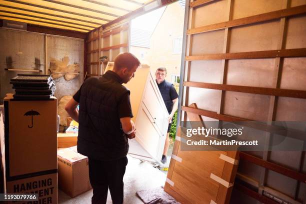 het laden van meubels in de verhuiswagen - verwijderen stockfoto's en -beelden