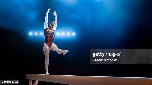 female gymnast standing on balance beam - gymnastics imagens e fotografias de stock