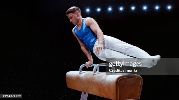 young man performing on pommel horse - gymnastics horse stock pictures, royalty-free photos & images