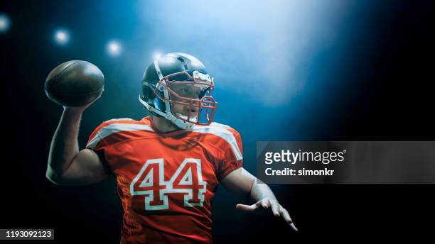 american football player throwing ball - quarterback imagens e fotografias de stock