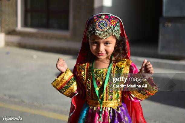 a young girl wearing a traditional pakhtun / afghani dress with traditional / cultural jewelry with happy facial expression - afghan bildbanksfoton och bilder