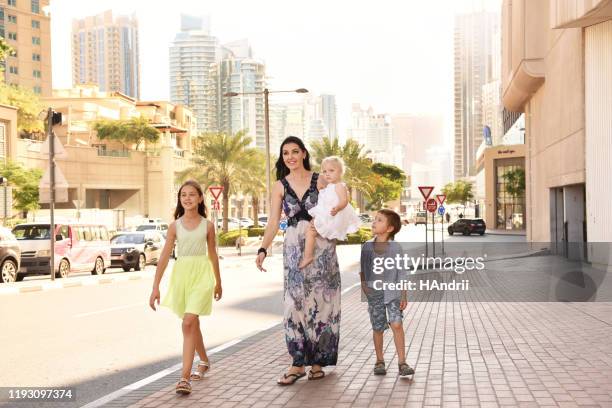 moeder met kinderen wandelen rond de stad. - city walk dubai stockfoto's en -beelden