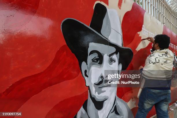 An artist paints a wall next to the mural of freedom fighter Bhagat Singh near a protest area in Jamia New Delhi India on 11 January 2020