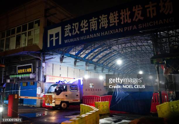 Members of staff of the Wuhan Hygiene Emergency Response Team drive their vehicle as they leave the closed Huanan Seafood Wholesale Market in the...