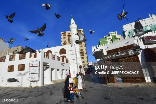 Pigeons fly in front of Al Maymaar Historical mosque in Al-Balad, a historical area in the Saudi Arabian port city of Jeddah, on January 11, 2020.