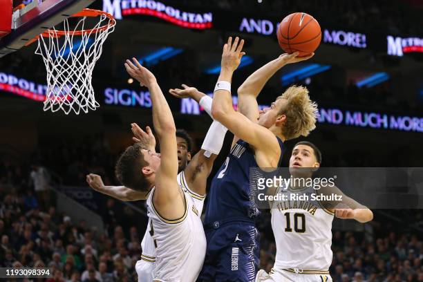 Mac McClung of the Georgetown Hoyas attempts a shot as Jeremiah Robinson-Earl, Saddiq Bey and Cole Swider of the Villanova Wildcats defend during the...