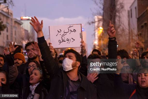 Iranians shout slogans as one of them holds-up a placard with a Persian script that reads, Death To The Liar, during a gathering to mark the victims...