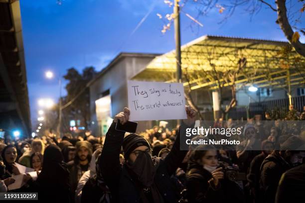An Iranian man holds-up a placard as he attends in front of a University to mark the memory of the victims of the Ukraine Boeing 737 passenger plane...