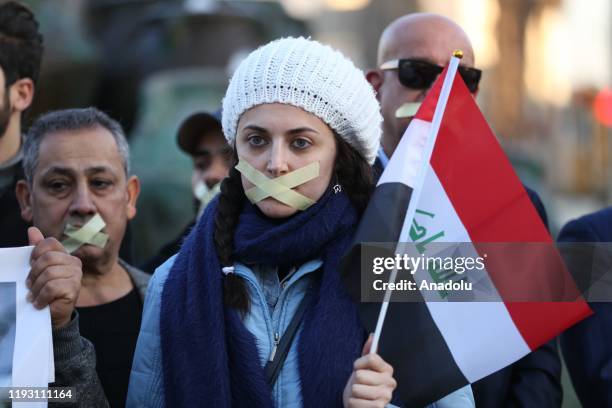 Woman with her mouth crossed-out with a tape takes part in a protest against the attacks towards journalists in Baghdad, Iraq on January 11, 2020. A...