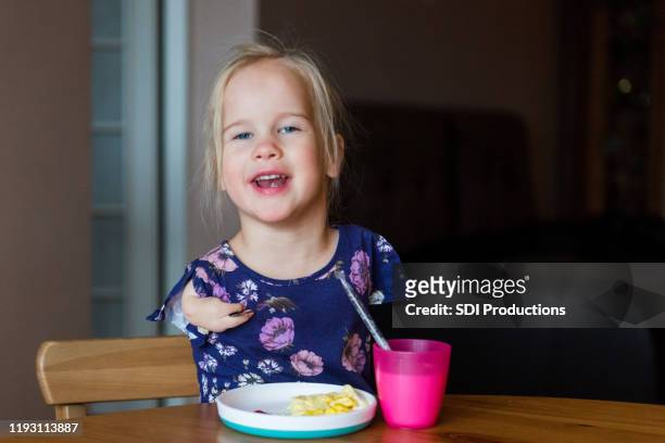 independent girl with disability enjoys her breakfast - deformed hand stock pictures, royalty-free photos & images