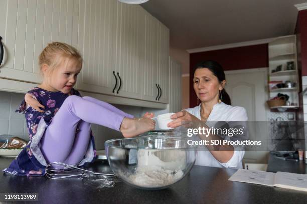 gehandicapte meisje bakt een cake met haar moeder - all purpose flour stockfoto's en -beelden