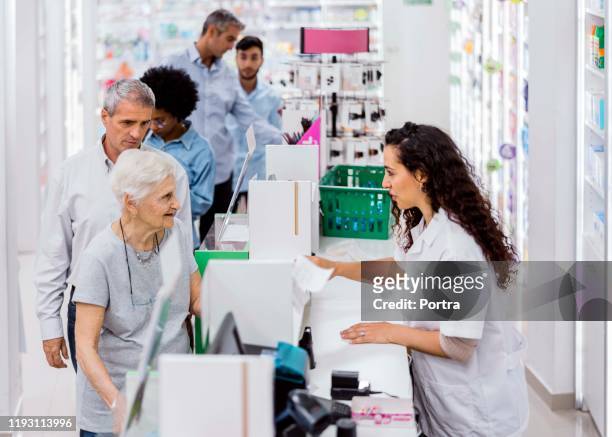 customers and chemist in drugstore - customers lining up stock pictures, royalty-free photos & images