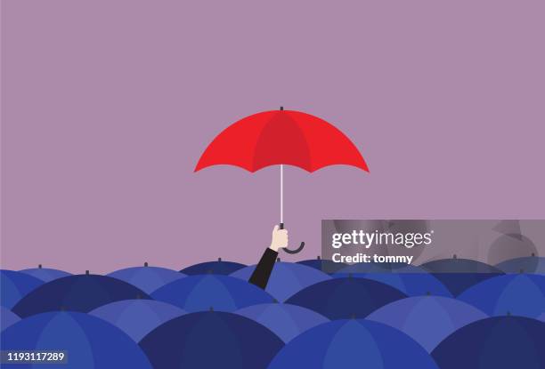 businessman holding a red umbrella in the crowd of a blue umbrella - individuality stock illustrations