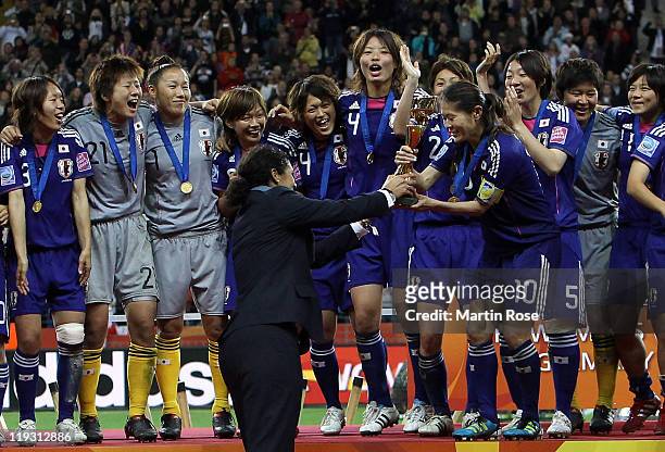 President Steffi Jones hands over the trophy to Homara Sawa of Japan after the FIFA Women's World Cup Final match between Japan and USA at the FIFA...