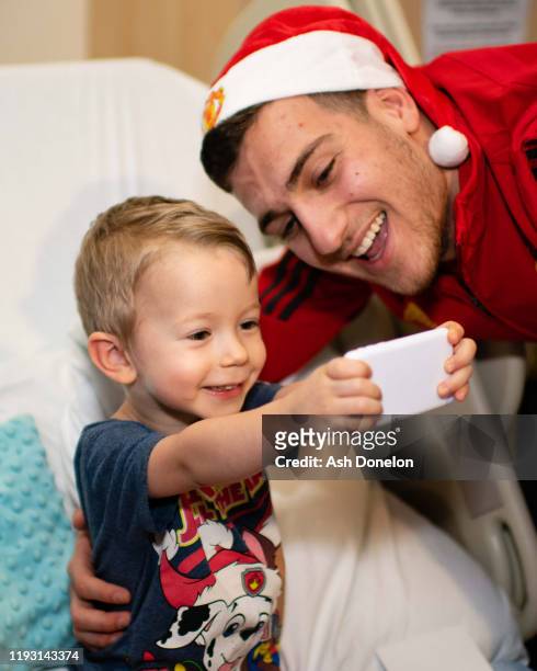 Diogo Dalot of Manchester United poses with Alan during the club's annual Christmas hospital visits at Royal Manchester Children's Hospital on...